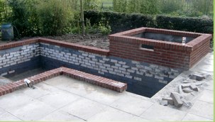 Aangelegde tuin met bestrating en een gemetselde plantenbak