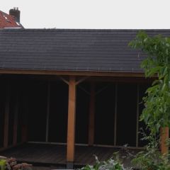 Maatwerk kapschuur bedekt met dakshingels en wanden van zwarte rabatdelen - Hoveniersbedrijf C.K. van Mourik West Betuwe, Tiel, Culemborg, Geldermalsen, Buren