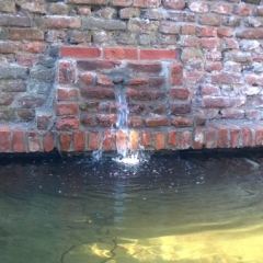 Gemetselde waterval tegen oude tuinmuur - Hoveniersbedrijf C.K. van Mourik