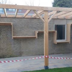 De houtberging tegen de muur: onder het hout en bovenop plaats om iets neer te zetten  - Hoveniersbedrijf C.K. van Mourik West-Betuwe Geldermalsen Tiel Culemborg