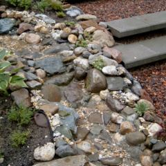 Natuurlijk ogende waterval van bonte Maaskeien - Hoveniersbedrijf C.K. van Mourik Tuinontwerp Katja Dupont IJzerhart Tuinarchitekt